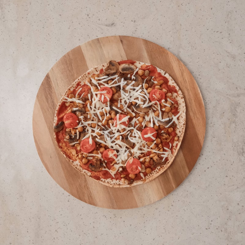 Breakfast Bean and Mushroom Pizza topped with mixed beans, sauteed mushrooms, cherry tomatoes, and melted mozzarella, served on a baking tray.
