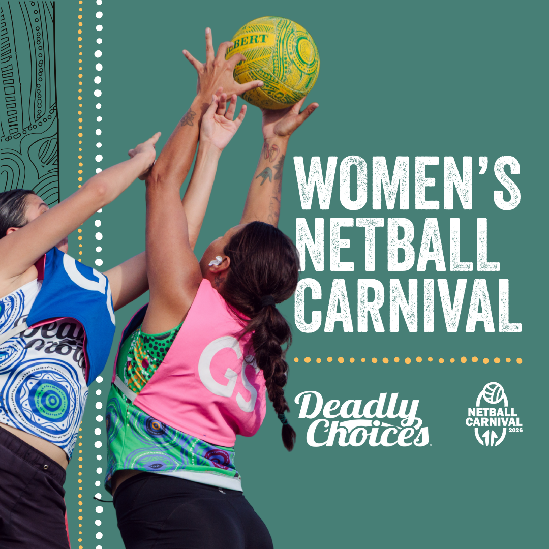 Women reaching for a netball during the Deadly Choices Women’s Netball Carnival, highlighting competitive play and community pride.