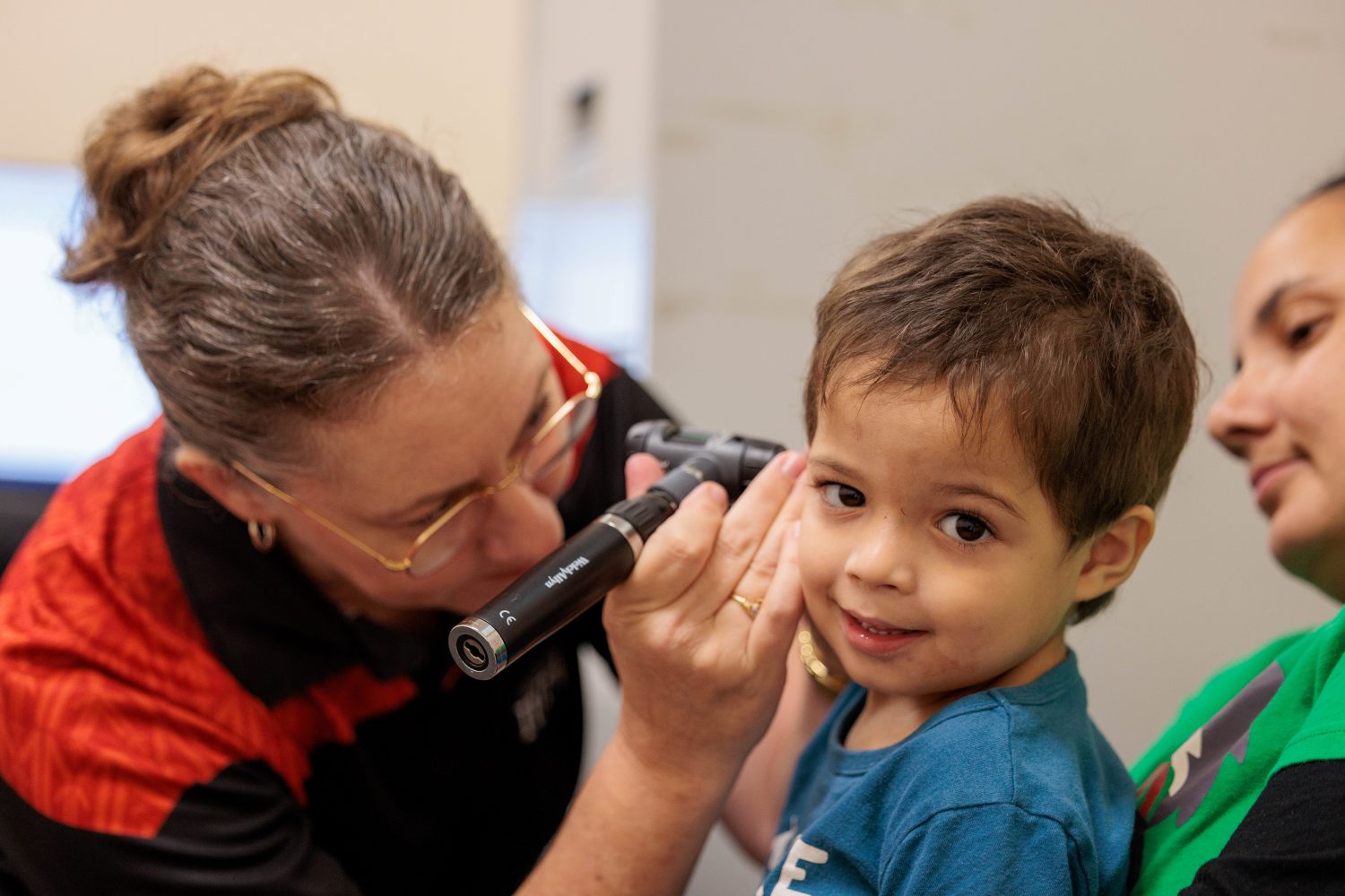 An audiologist from IUIH is checking kid's hearing