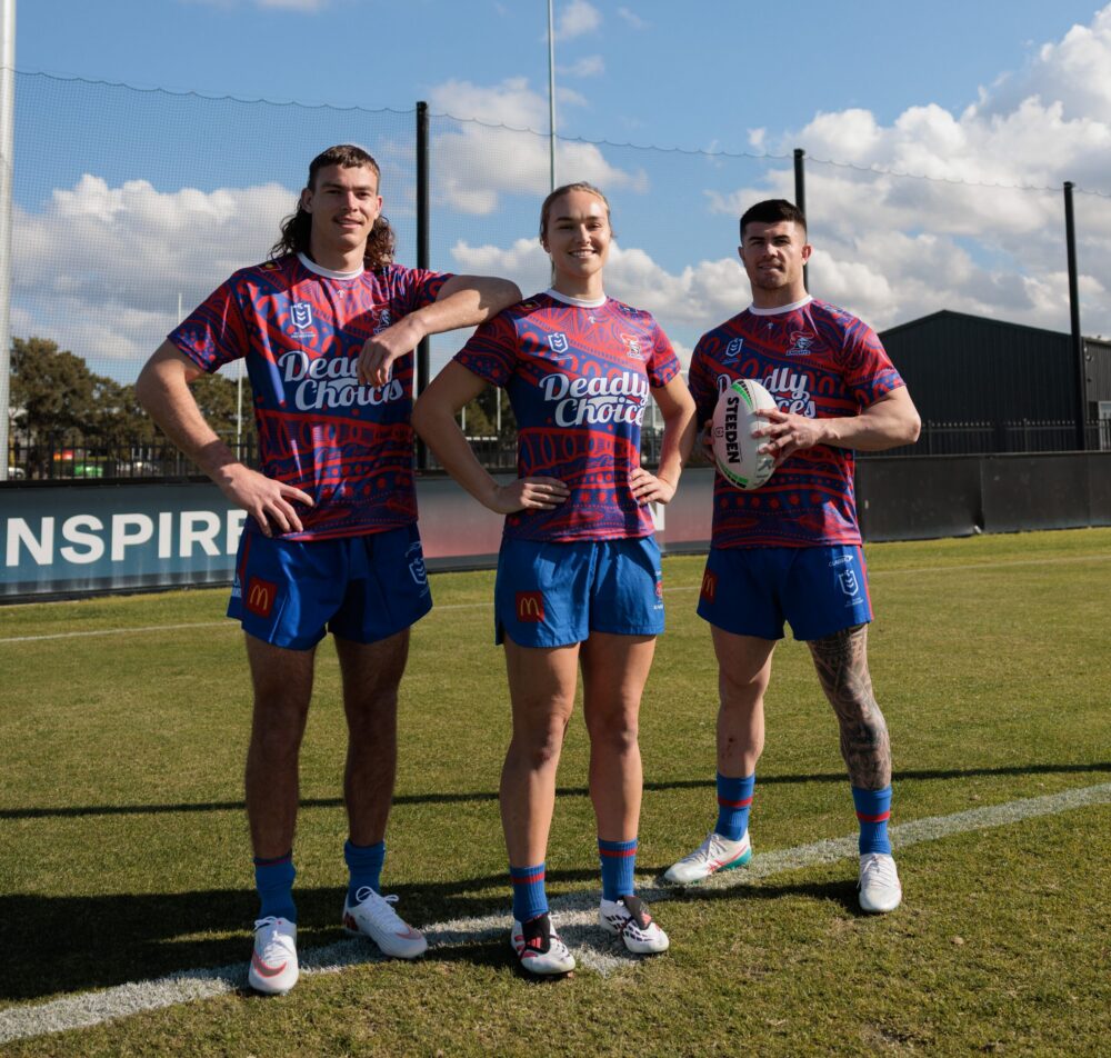 The Newcastle Knights players model the new Deadly Choices 715 Health Check shirt.